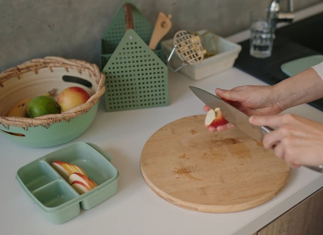 devojka seče jabuku u dečijoj kutiji za poneti