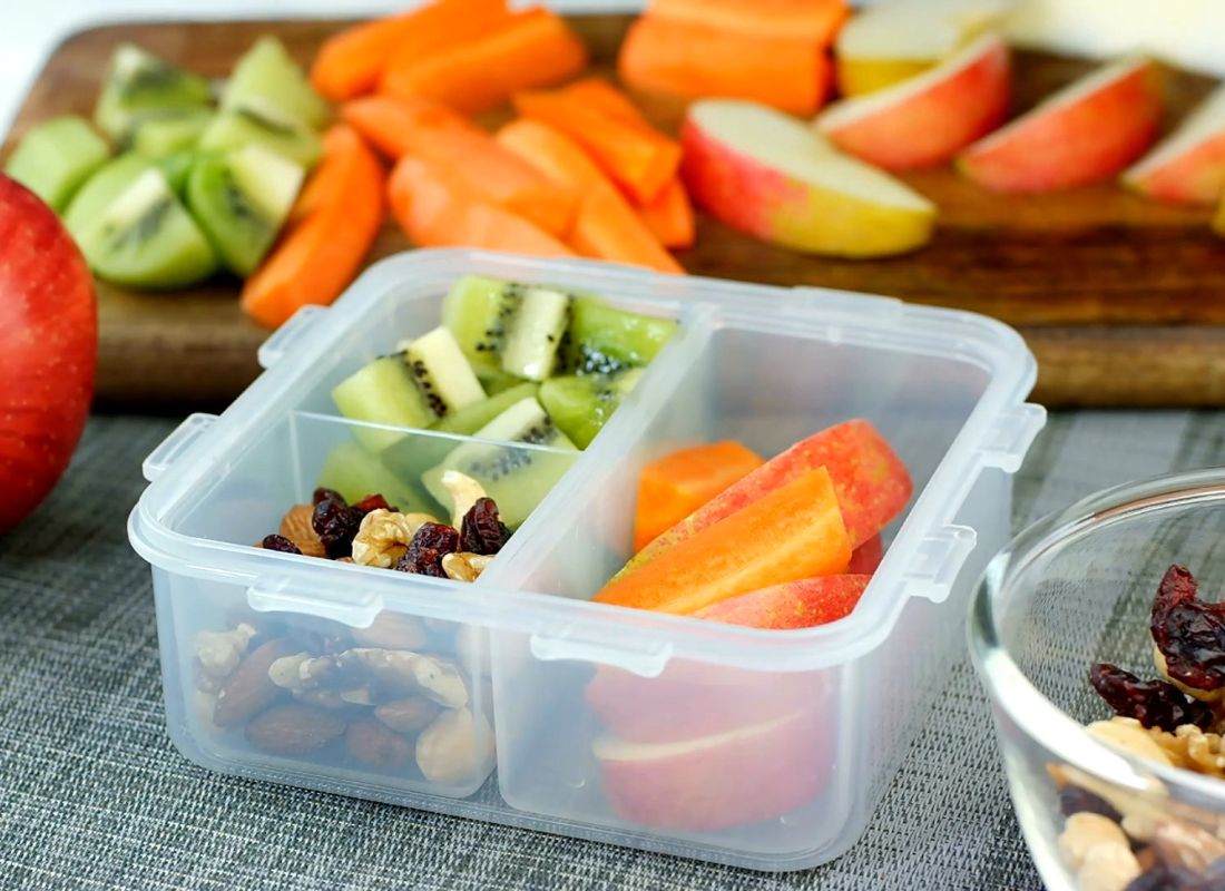 prikaz zdrave užine spakovane u kutiji, orašasto povrće, kivi i jabuke