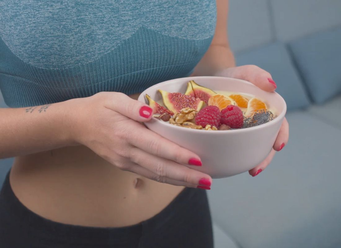 devojka drži činiju sa voćem kao zdrava užina